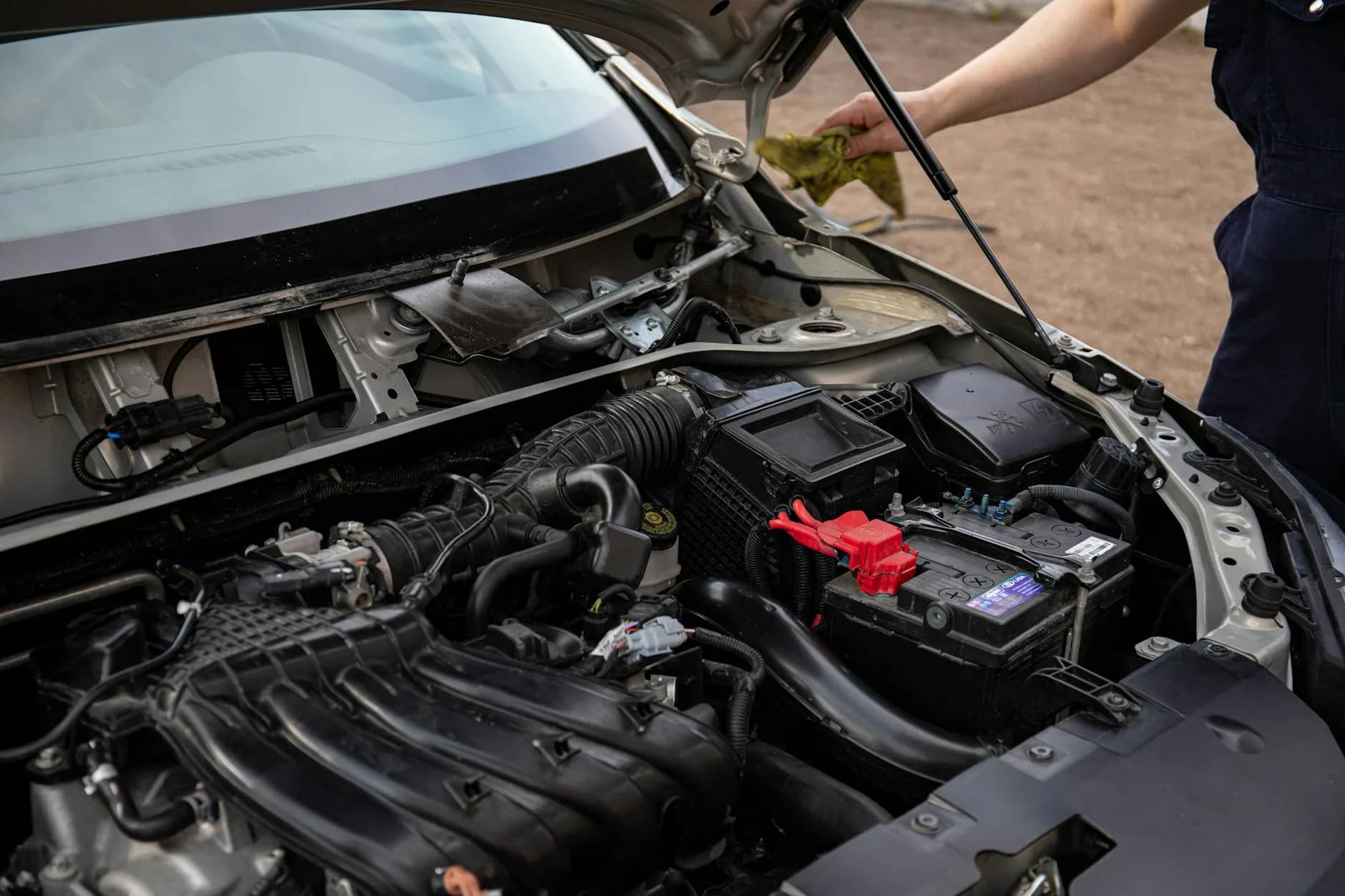 Car battery being replaced in an engine bay