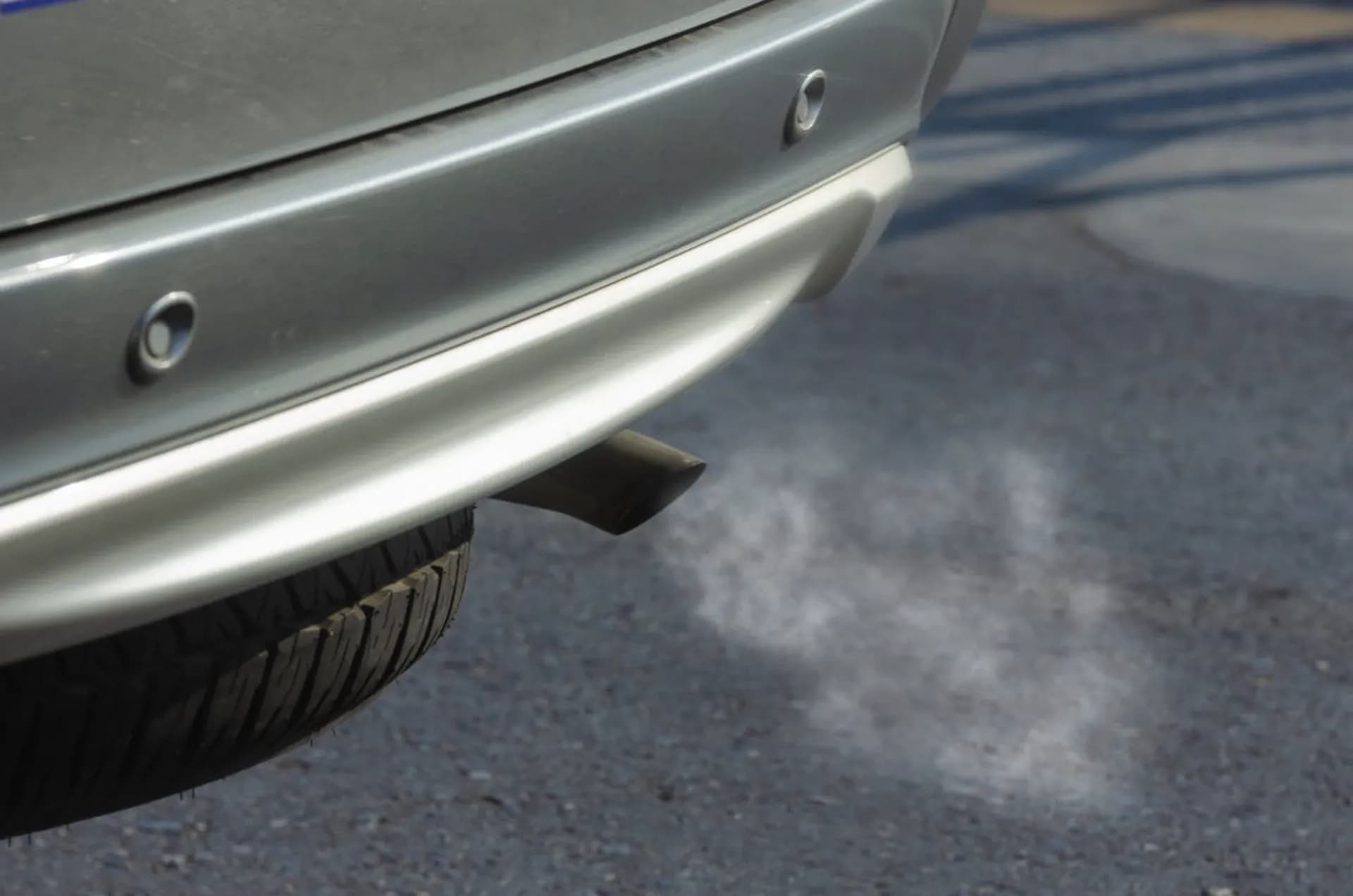 Close-up of a car exhaust pipe and system underneath a vehicle
