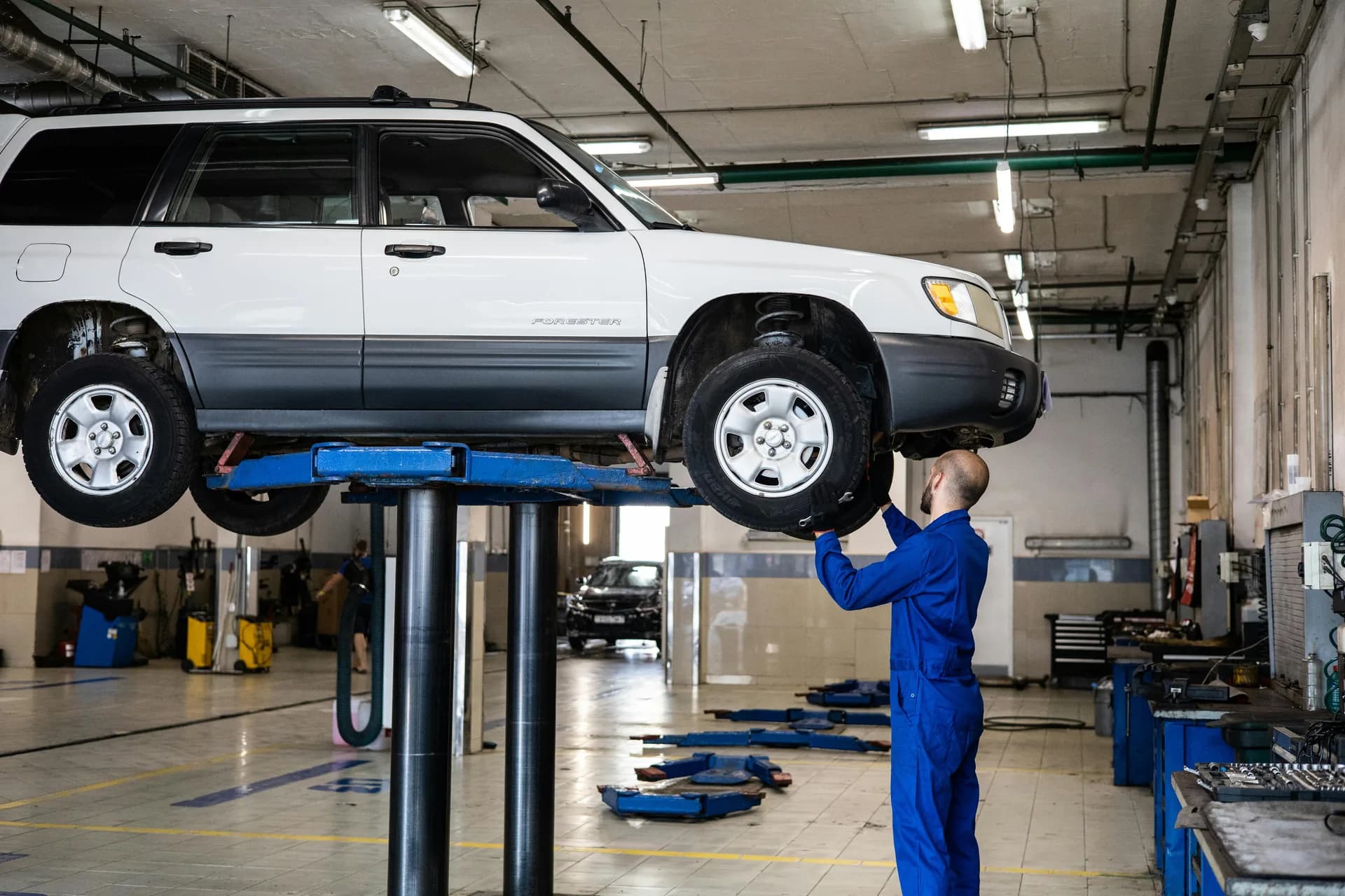Car raised on a vehicle ramp for MOT inspection at a UK garage