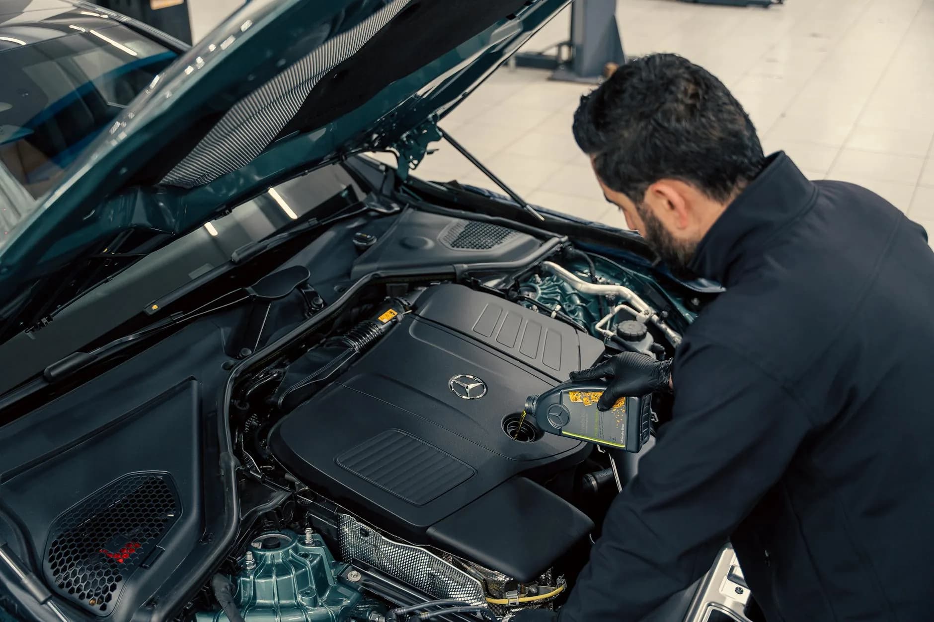 Mechanic performing an oil change during a full car service