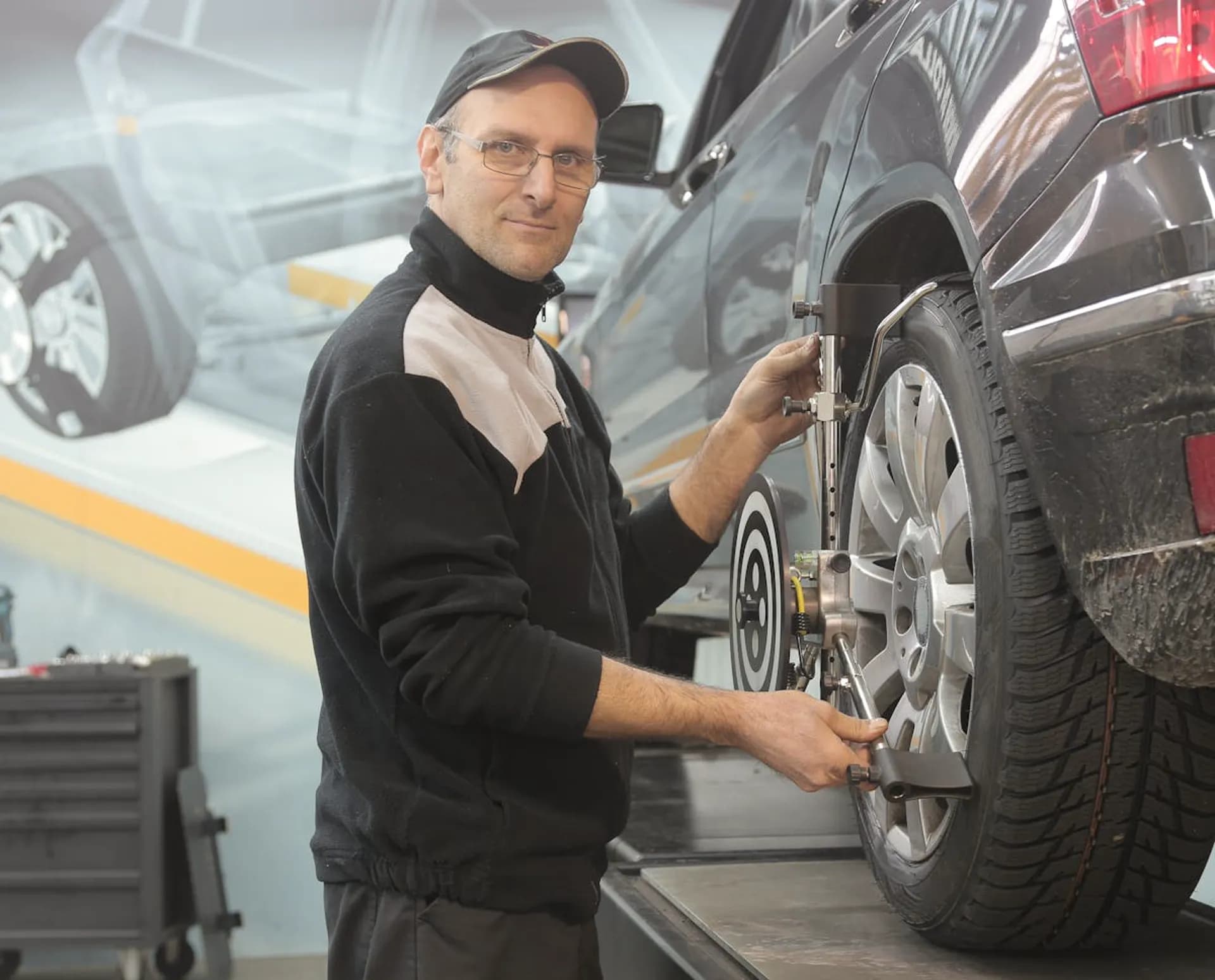 Laser wheel alignment equipment attached to a car wheel in a garage