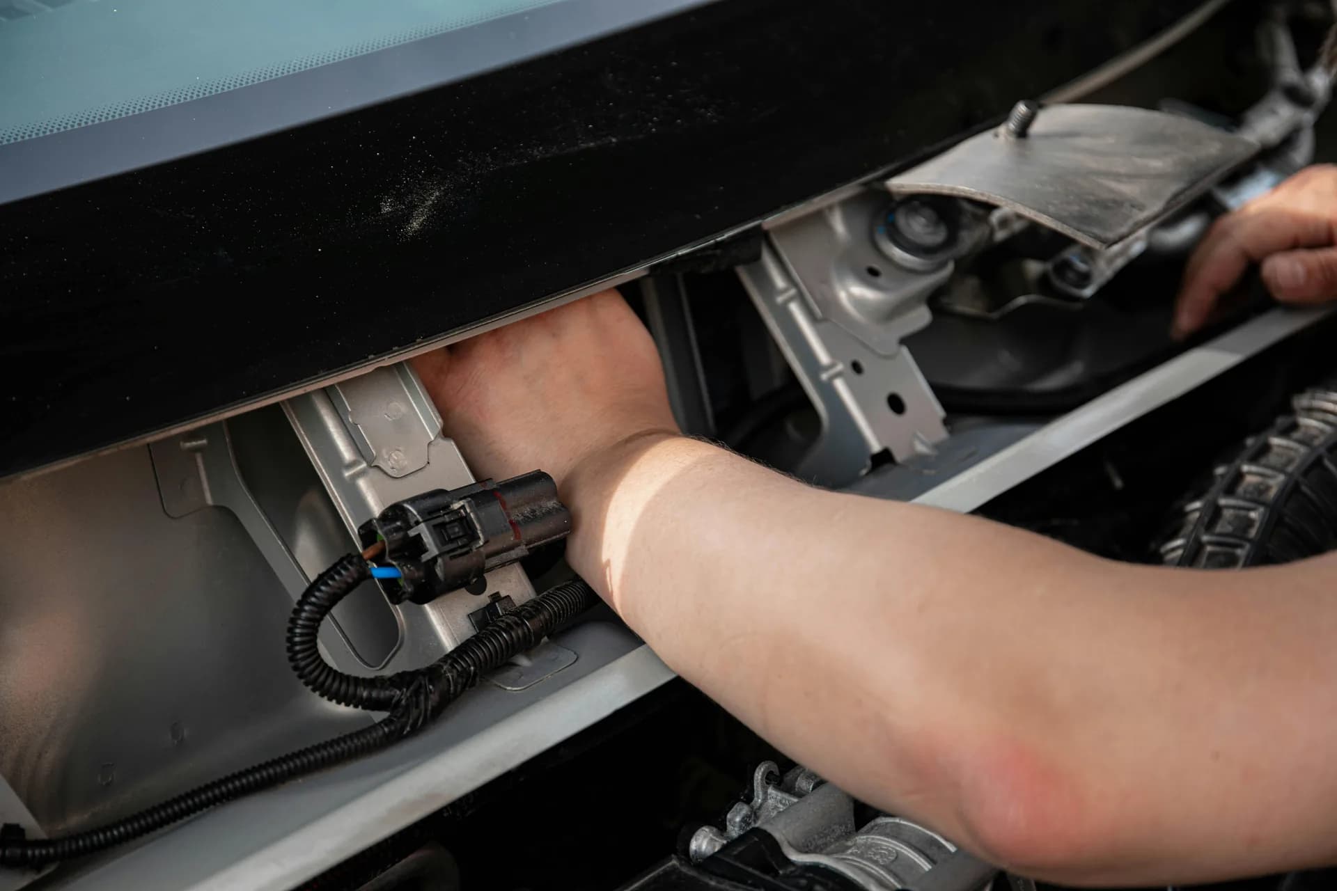 Mechanic diagnosing a car electrical wiring fault